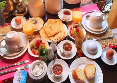 a table with a breakfast of eggs bread and fruit at Riad NaaNaa Bed & Breakfast in Marrakech