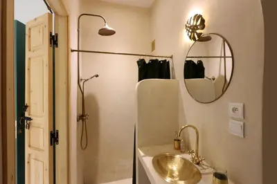 a bathroom with a sink and a shower and a mirror at Riad NaaNaa Bed & Breakfast in Marrakech