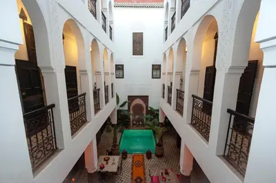 an empty hallway of a building with a green table at Riad Khabia & Spa in Marrakech