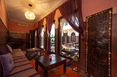 a living room with a table and a large window at Riad Khabia & Spa in Marrakech