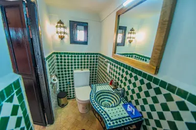 a bathroom with a toilet and a mirror at Riad Khabia & Spa in Marrakech