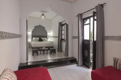 a bedroom with a bed and a table in a room at Riad le Voile d'Orient in Marrakech