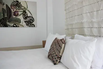 a bedroom with a bed with white sheets and pillows at Riad El Ouarda in Marrakech