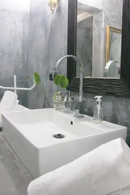 a white sink in a bathroom with a mirror at Riad El Ouarda in Marrakech