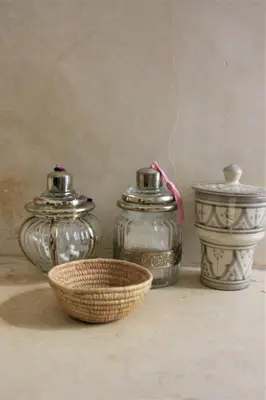 three glass jars and a bowl on a table at Riad El Ouarda in Marrakech