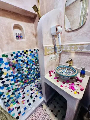 a bathroom with a sink and a mosaic floor at Riad Eva in Marrakech