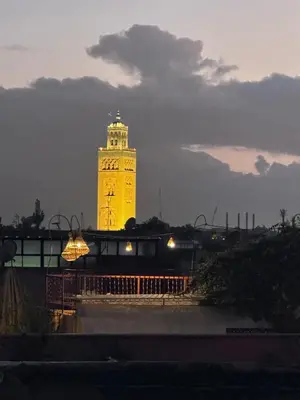 a large tower with a clock on it at night at Riad Eva in Marrakech