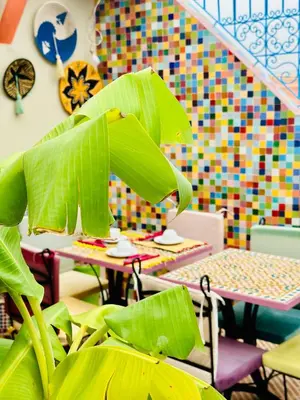 a dining room with a table and a plant at Riad Eva in Marrakech