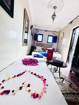 a room with a bed with pink flowers on it at Riad Eva in Marrakech