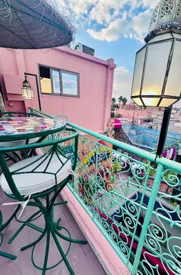 a balcony with a table and a lamp at Riad Eva in Marrakech