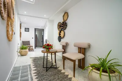 a living room with two stools and a table at Riad La Croix Berbere Deluxe in Marrakech