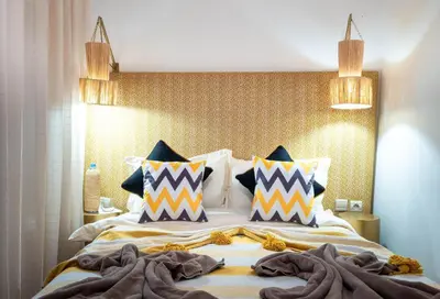 a bedroom with a large bed with colorful pillows at Riad La Croix Berbere Deluxe in Marrakech