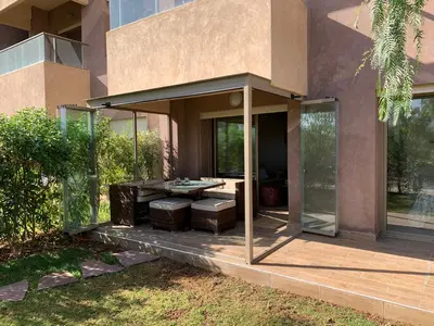 a house with a patio with a table in it at Marrakech Prestigia Jade Golf Piscine in Marrakech