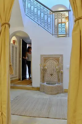 a woman standing in a hallway next to a door at Riad Dar Jabel in Marrakech