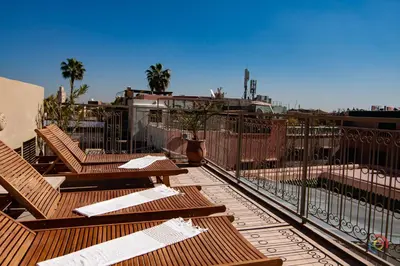 a deck with wooden benches and a fence at Riad Dar Jabel in Marrakech
