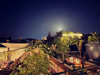 a view of a city at night with plants at Riad Chocolat in Marrakech