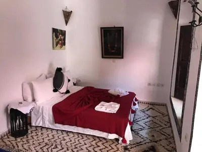 a bedroom with a bed with a red blanket at Riad Naya in Marrakech