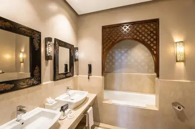 a bathroom with two sinks and a bath tub at Palmeraie Golf Suites By Pickalbatros in Marrakech