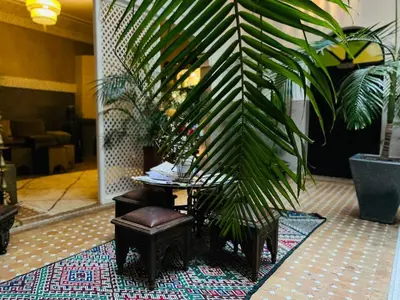 a chair and a table in a lobby with a plant at Riad Dabachi in Marrakech