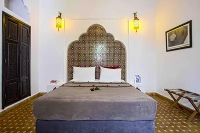 a bedroom with a large bed with a large headboard at Riad Dabachi in Marrakech