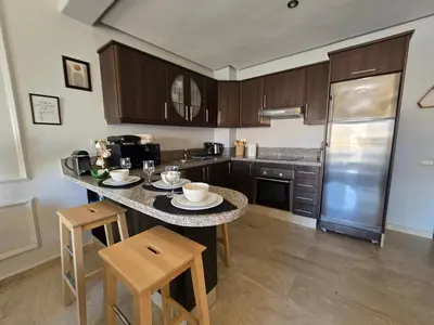 a kitchen with a table with chairs and a counter top at Cosy Bagatelle Houses 1 & 2 in Marrakech