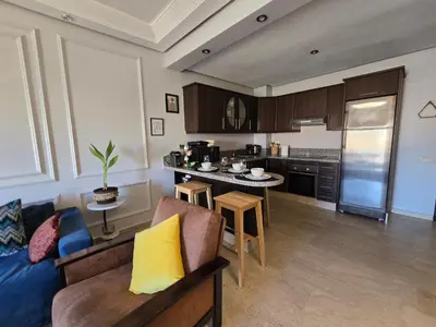 a living room with a couch and a kitchen at Cosy Bagatelle Houses 1 & 2 in Marrakech