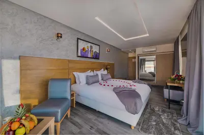 a hotel room with a large bed and a chair at Stars Hotel & Spa in Marrakech
