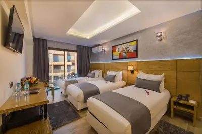 a hotel room with two beds and a television at Stars Hotel & Spa in Marrakech