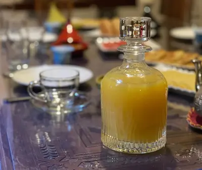 a bottle of orange juice sitting on a table at RIAD SHAJARA in Marrakech