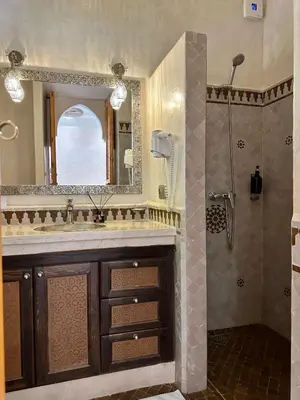 a bathroom with a sink and a shower with a mirror at RIAD SHAJARA in Marrakech