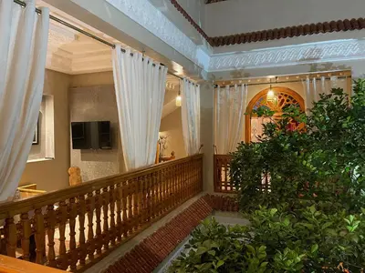 a stairway with white curtains and a plant at RIAD SHAJARA in Marrakech