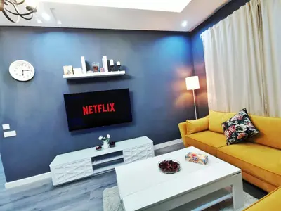 a living room with a couch and a tv at La saphir marrakech in Marrakech