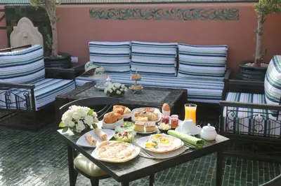 a table full of food on a table with chairs at Riad Wazani Square & SPA in Marrakech