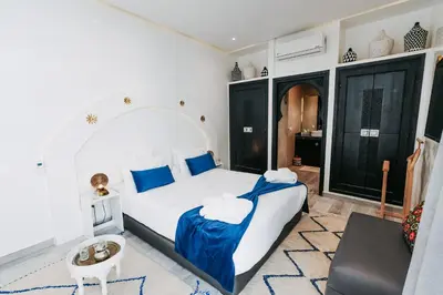 a bedroom with a large white bed with blue pillows at RIAD NOLITA & SPA Kasbah in Marrakech