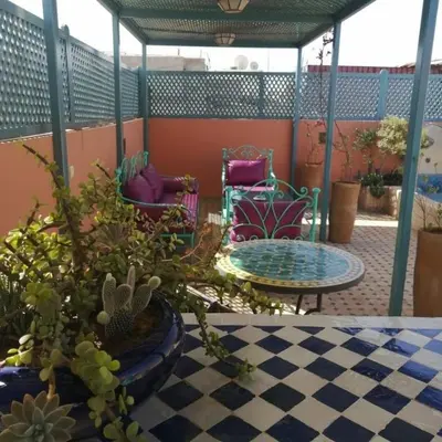 a patio with chairs and a table with plants at Dar 14 Marrakech in Marrakech