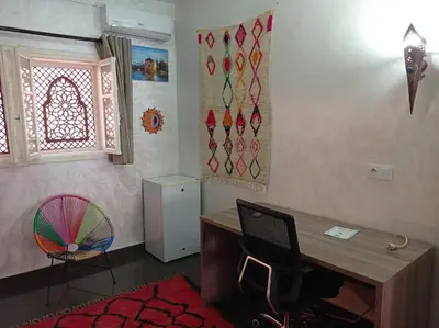 a room with a desk and a chair and a window at Stork Marrakech Luxury Hostel in Marrakech