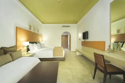 a hotel room with a bed and a desk at Hotel Riu Tikida Palmeraie - All Inclusive in Marrakech