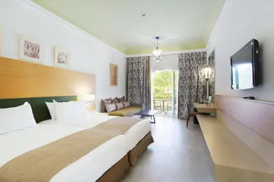 a hotel room with a bed and a tv at Hotel Riu Tikida Palmeraie - All Inclusive in Marrakech