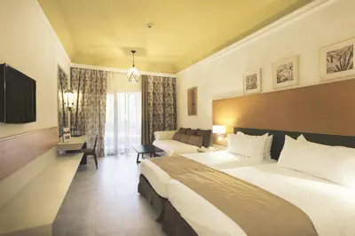 a hotel room with a large bed and a couch at Hotel Riu Tikida Palmeraie - All Inclusive in Marrakech