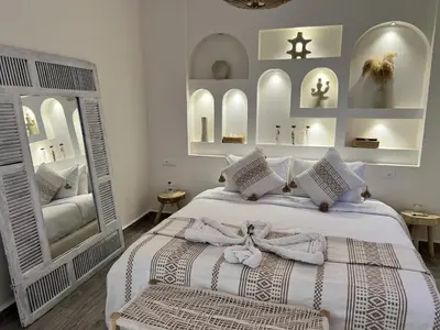 a bedroom with a white bed with towels on it at RIAD RIME QOUSSAI in Marrakech