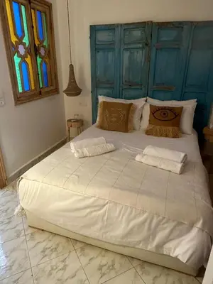 a large white bed in a room with a stained glass window at RIAD RIME QOUSSAI in Marrakech