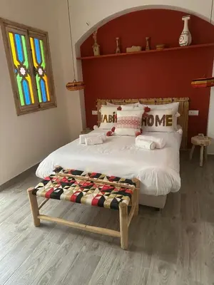 a bedroom with a bed and a stained glass window at RIAD RIME QOUSSAI in Marrakech