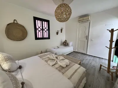 a bedroom with two beds and a window at RIAD RIME QOUSSAI in Marrakech