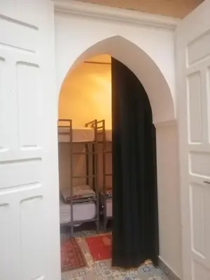 an archway leading into a room with a bunk bed at Hostel Laksour in Marrakech