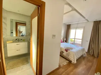 a bedroom with a bed and a sink and a mirror at RIAD GARDEN LUXURY AGDAL in Marrakech
