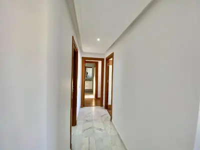 a hallway with white walls and a marble floor at RIAD GARDEN LUXURY AGDAL in Marrakech