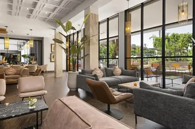 a lobby with couches and tables and windows at Hotel Riu Tikida Garden - Adults Only - All Inclusive in Marrakech