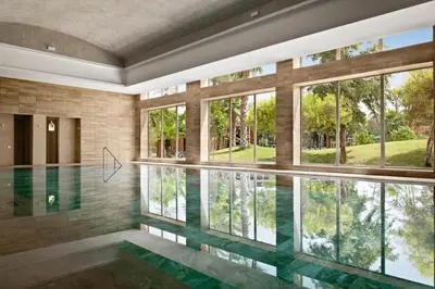 a pool in a house with glass windows at Hotel Riu Tikida Garden - Adults Only - All Inclusive in Marrakech