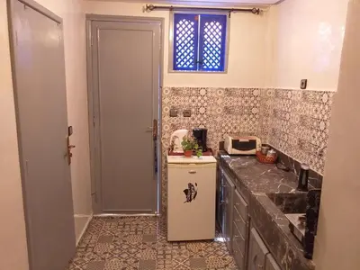 a small kitchen with a refrigerator and a window at studio Dar Rmila in Marrakech