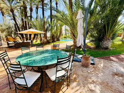 a patio with a table with chairs and an umbrella at Villa Ross in Marrakech